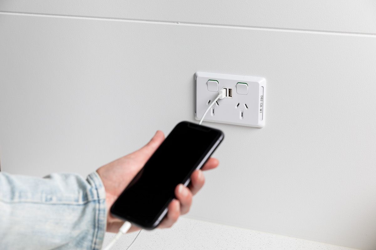 phone plugged in charging on wall outlet