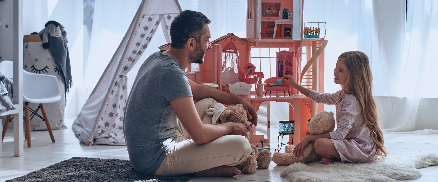 Father and daughter sitting on the floor playing