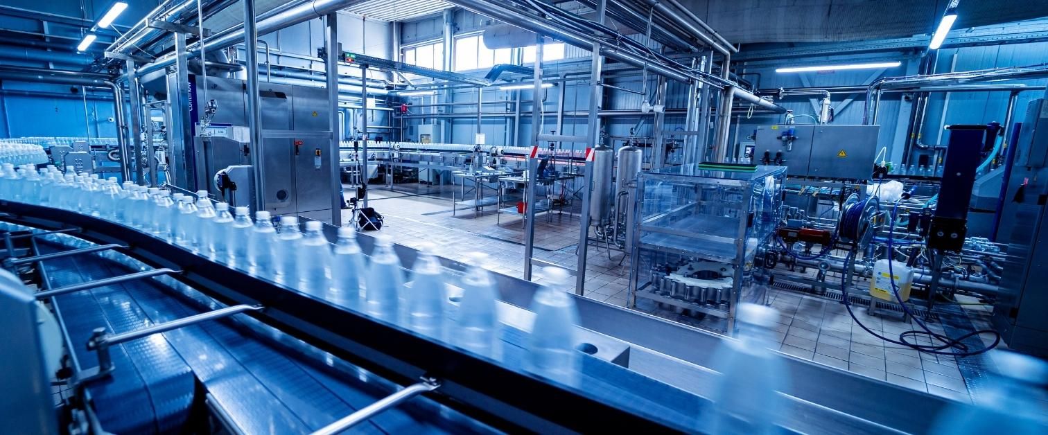Conveyor belt with bottles of drinking water at a modern beverage plant.