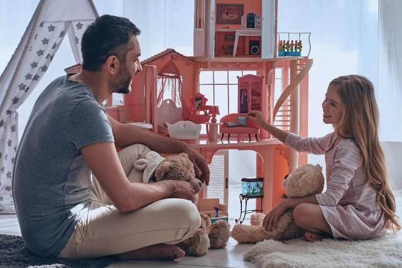 Father and daughter sitting on the floor playing